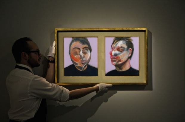 An expert places a Francis Bacon self-portrait up on a wall.