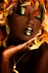 A photo of a beautiful African American woman with blonde hair and vivid makeup.