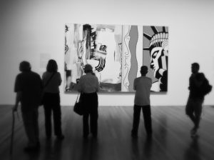 A photo of people looking at a painting at the De Young Museum in San Francisco.